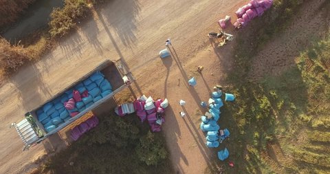 aerial static view of workers carrying rice sacks into a big truck 