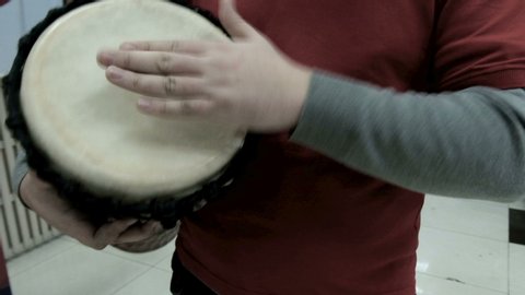 2019-12-18 Kostanay, Kazakhstan. Ethnic music in a modern building interior. Close-up of a drummer's hand. Real sound and rhythm. Percussion musical instrument, which is played with the hands.