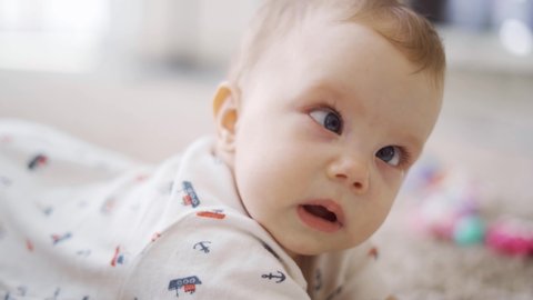 Cute Caucasian baby girl looking at the camera with crossed eye at home. Shot in 4k resolution