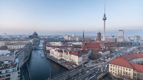 Berlin city skyline at dusk. Panoramic view on Fernsehturm TV tower, river Spree and Berliner Dom. City lights switch on. Time lapse video