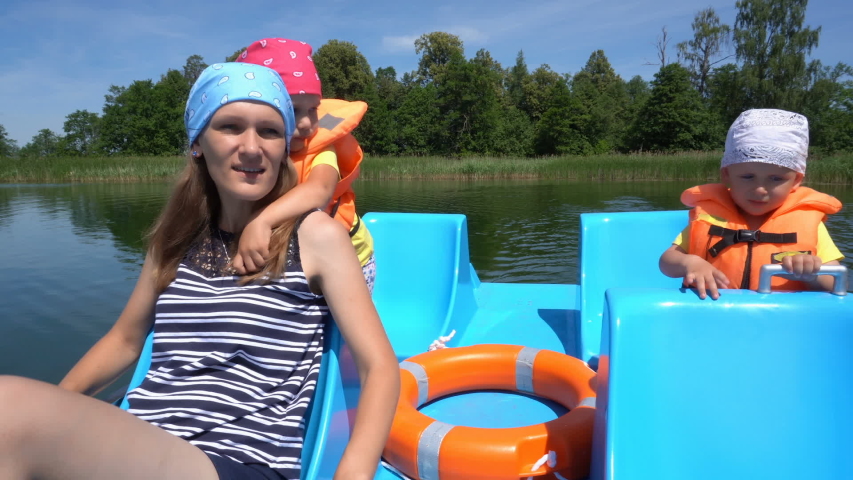Son,daughter and mother in life jackets floating on catamaran boat. Gimbal movement shot.