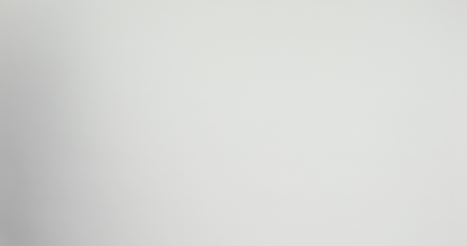 girl in a white coat straightens her hair with a curling iron on a white background