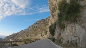Epic slow motion footage of driving through beautiful mountain landscape with Mediterranean sea on horizon during sunset. Famous winding road to sight Sa Calobra port. Mallorca, Spain. 4K POV video