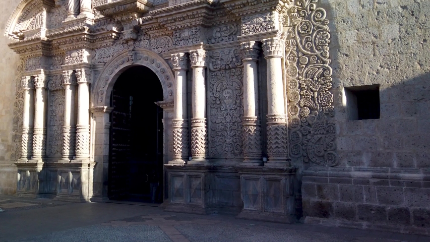 Baroque style in temple made by spanish conquerors. The Church of The Company with carved details of flowers, statutes in white rock, Arequipa City, Peru
