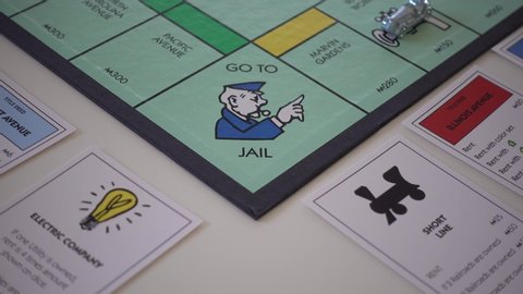 Orlando, FL/USA-12/20/19: Person playing the board game Monopoly and landing on Go to Jail.  Concept business crimes.