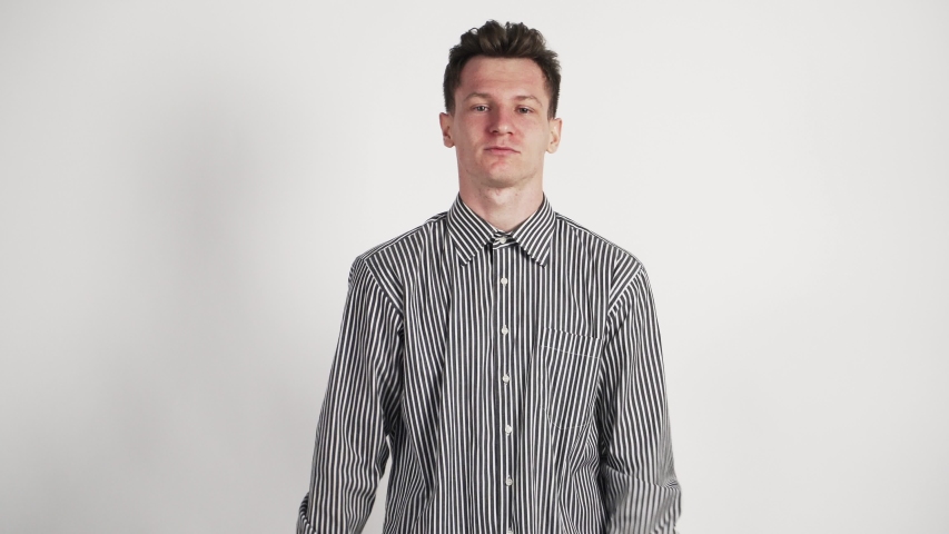 The young guy Caucasian appearance, in his shirt show his emotions of joy and victory. On a white background.