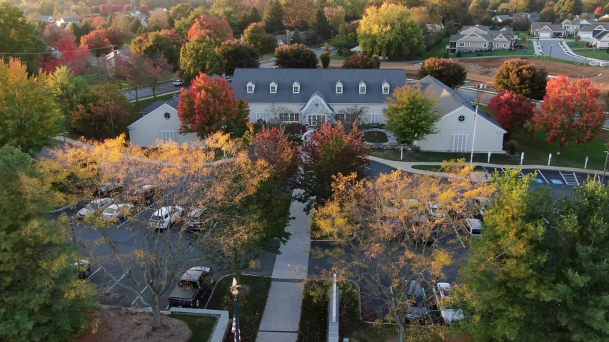 Community center, public library beside neighborhood with autumn fall colorful leaves, aerial drone shot