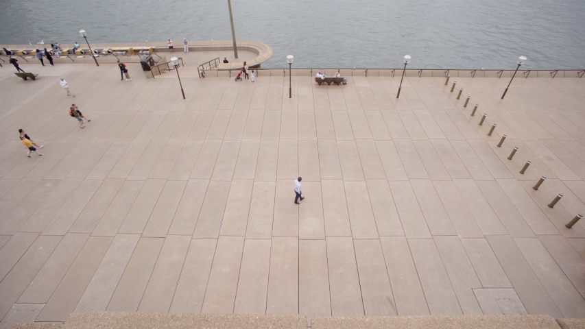 Lookin down from the stairs of Sydney Opera House and watching people go by on a cloudy day.