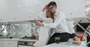 Funny boyfriend and girlfriend rotating doing selfie at home on a kitchen. Happy and smile.