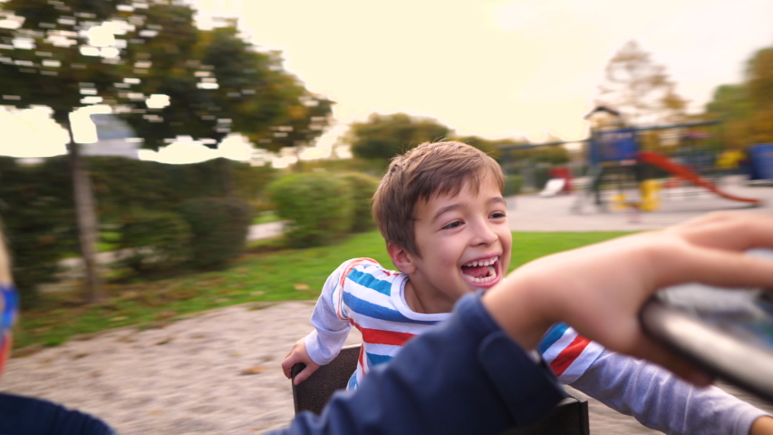 A boy spinning on a Merry-Go-Round with his friends in slow motion Royalty-Free Stock Footage #1043408305
