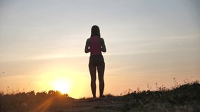 Happy woman jumping on beach enjoying sunset on summer travel vacation holiday. Happiness and bliss concept video with female jumping of joy celebrating in silhouette. SLOW MOTION 4k