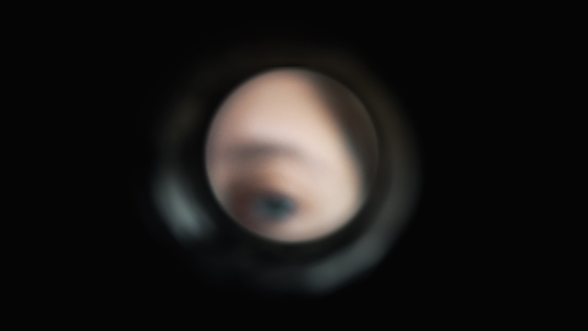 Looking Through Peephole In Door Viewer. Extreme close up of the eye of a girl peeping through a peephole in door viewer Royalty-Free Stock Footage #1043420896