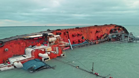 The wreck of the ship, the tanker. The ship with navigation equipment turned on its side. Environmental disaster that leaked oil from tanker. aerial drone shot.