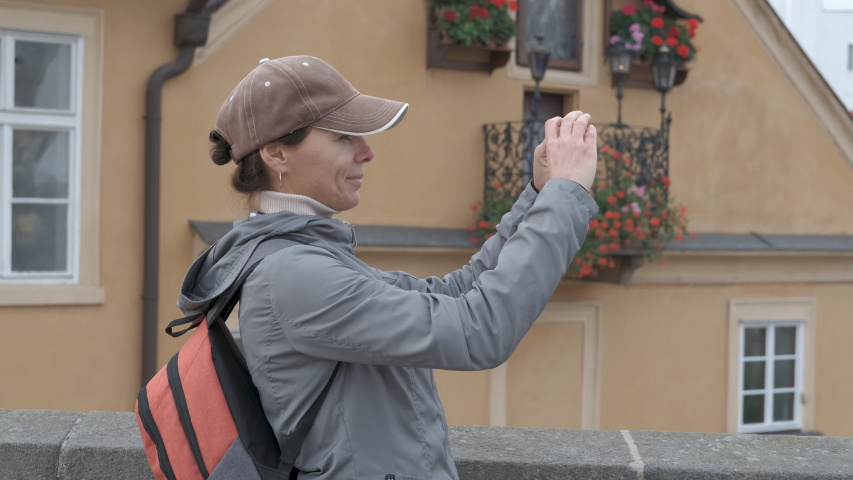 Tourist takes pictures on a smartphone. A woman makes a photo on the telephone of old Europe.