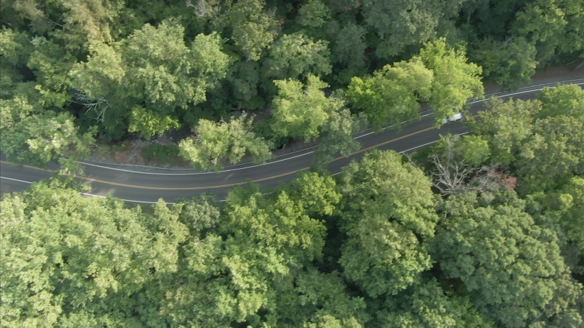 Aerial: flying above a forest and country road on the outskirts of the Shenandoah National Park. Virginia, USA 