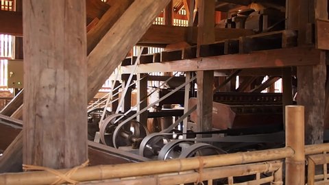Old technology of Rice milling machine. Traditional ancient machine for separating paddy and rice. Important device in rice agriculture. Ancient wood rice milling in urban factory.