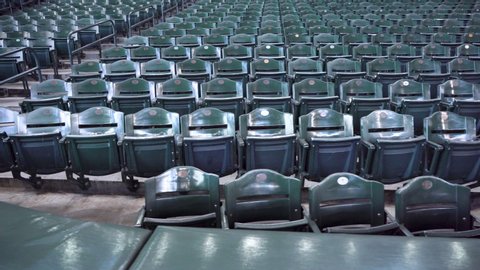 Indoor Stadium Seating with Hundreds of Empty Green fold up seats.