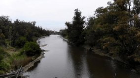 aerial video touring the river with forestation to its surroundings. La Floresta Uruguay