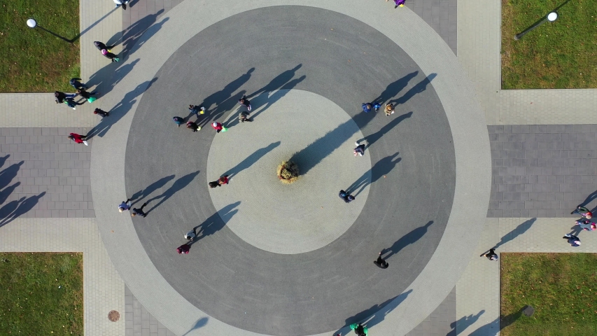 People and Shadows Moving on Circular Square, Top Down Bird Eye Cinematic Ascending Aerial View Royalty-Free Stock Footage #1043458996