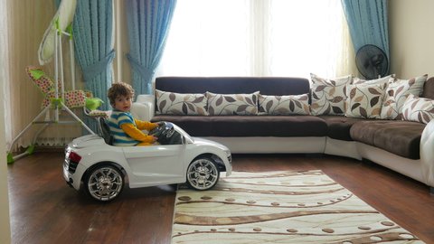 Small kid playing toy batery car at home