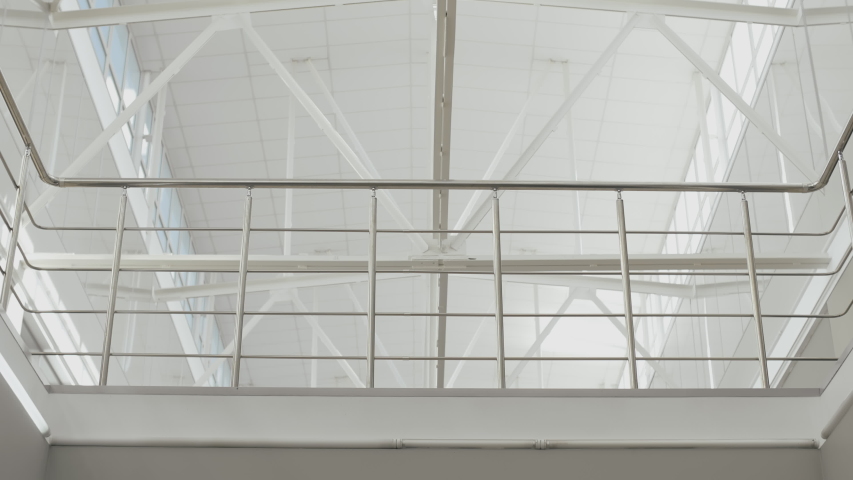 Bottom view of two confident business partners meeting in office hallway and shaking each other hands. Central composition