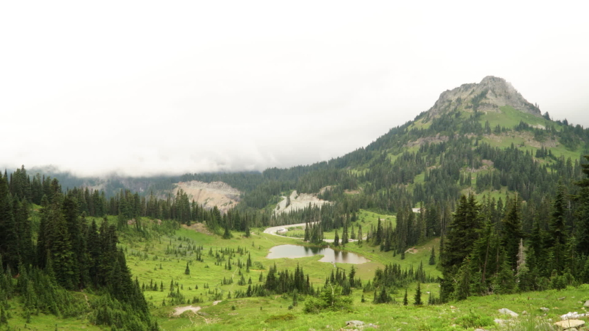 Time Lapse of Clouds Moving Over Summit of Mount Rainier and Valley With Pond, Meadow and Evergreen Fores, Olympic National Park, Washington USA