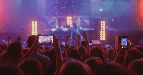 People are filming a singer’s concert on smartphone. Сrowd of people at an artist's concert, filming a performance on the phone.