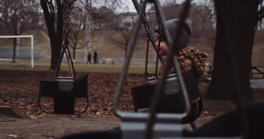 Toddler girl playing outside in a Toronto park during the late fall. Cinematic 4K footage.