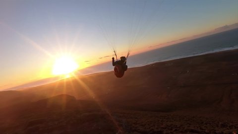 Beauty of free paragliding flying at sunset in ocean coast mountains in Morocco. Adrenaline adventure Slow motion