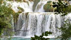 Waterfalls Krka, National Park, Croatia. Beautiful streams slowly flows in Krka National Park between trees and grass, cascade of waterfalls. Slow motion video of water, river, stream, waterfalls.