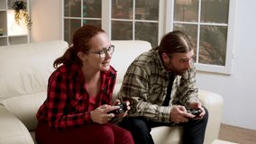 Hipster couple upset because their lose while playing video games using wireless controller.
