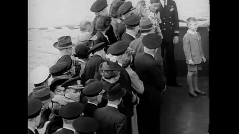 CIRCA 1945 - Civilians and servicemen watch the USS Midway get christened.
