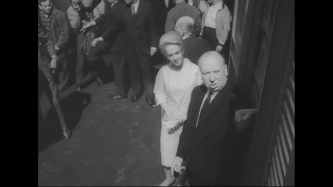 CIRCA 1963 - Tippi Hedren and Alfred Hitchcock unleash a cage of pigeons at the New York City premiere of "The Birds."