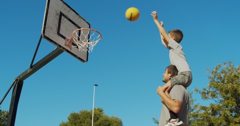 Father and son playing basketball.
