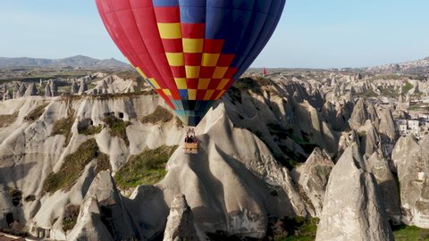 Colourful Red Blue Yellow Colours Hot Air Baloons Aerial Drone Flight. The great tourist attraction of Cappadocia. Cappadocia landscape with rocks and houses. Goreme, Cappadocia, Turkey.