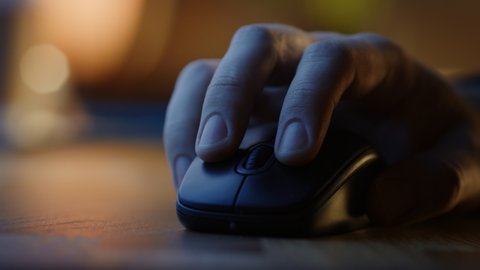 Close-up Macro Shot: Person's Hand Using Wireless Computer Mouse, Scrolls through Apps and Websites with a Wheel and Clicks on Buttons. In the Background Evening Light