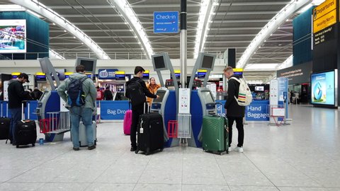 HEATHROW AIRPORT, LONDON - MARCH 16, 2019: British Airways passengers use self service kiosks to check in for their flight at Terminal 5, Heathrow International Airport in London, UK.