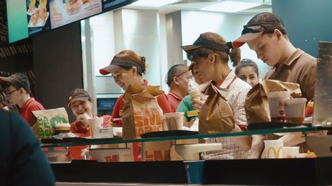 Moscow, Russia - December 15, 2019: Counter service in a McDonald's. A friendly managers of McDonald's verified with payment check and takes an order to the client. Effective Fast Food Management.