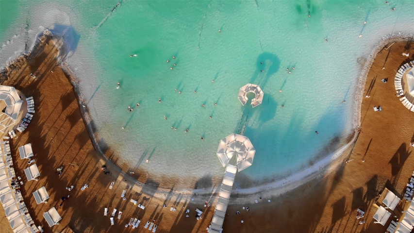 Aerial footage over Beach with People bathing and swim at Dead Sea
Drone view over Dead Sea with People bathes and swims at sunset
