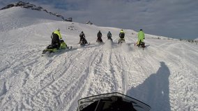 POV: Ryder is chasing a group of snowmobilers on a snow sports motorcycles. group riding on elite snowmobiles in a mountain valley. the concept of winter motorcycle tourism. First-person view