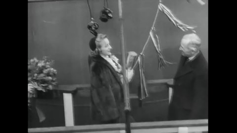 CIRCA 1944 - Senator Harry Truman looks on as his daughter Margaret christens the USS Missouri.