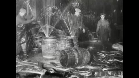 CIRCA 1920s - Policemen break up barrels filled with alcohol in a garage during the Prohibition Era in Chicago in Illinois.