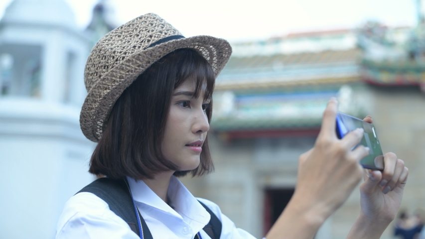 Travel concept. A beautiful girl is enjoying taking pictures in the city. 4k Resolution.