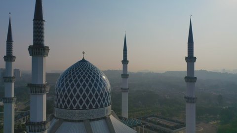 Sunrise With Blue And White Mosque At Sultan Salahuddin Abdul Aziz Shah Alam Mosque Shah Alam Malaysia Aerial Tilt Up During Sunrise 4K Cinematic Footage