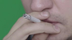 Cigarette in the mouth of a smoker. Close-up. Slow motion. Chroma Key. Green background.