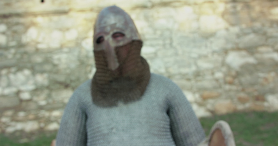 Portrait of armed and wore soldier shows weapons at camera. Slowly in 4K