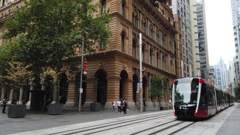 Sydney NSW Australia - Dec 15 2019: street view near Martin place station with new red passenger tram light rail. public transport train line pass Central business district and historic buildings