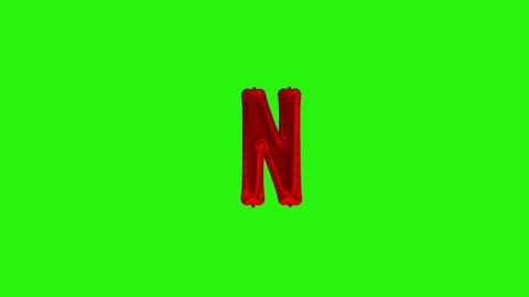 Red letter N. Red foil helium balloon alphabet floating on green screen