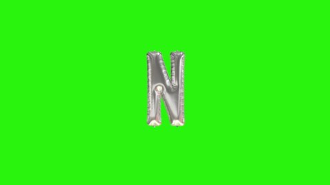 Silver letter N. Silver foil helium balloon alphabet floating on green screen