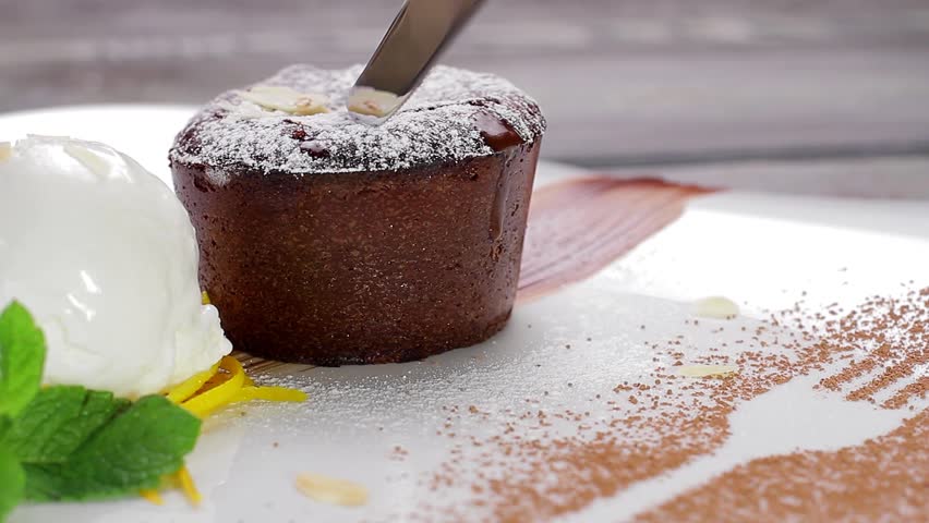 Warm cut chocolate fondant with ice cream and cinnamon. Beautiful serving dishes. Royalty-Free Stock Footage #10436372